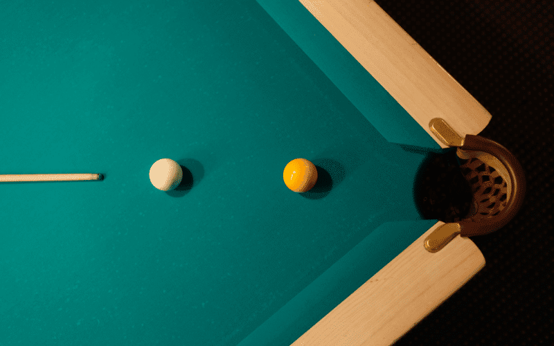 An AI-controlled robotic arm lines up a shot on a billiards table, calculating angles and trajectory with precision