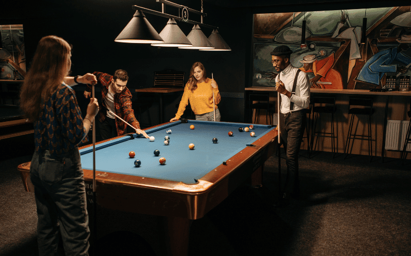 Women in billiards, focused and disciplined, lining up shots and strategizing, surrounded by the structure of the billiards table and equipment